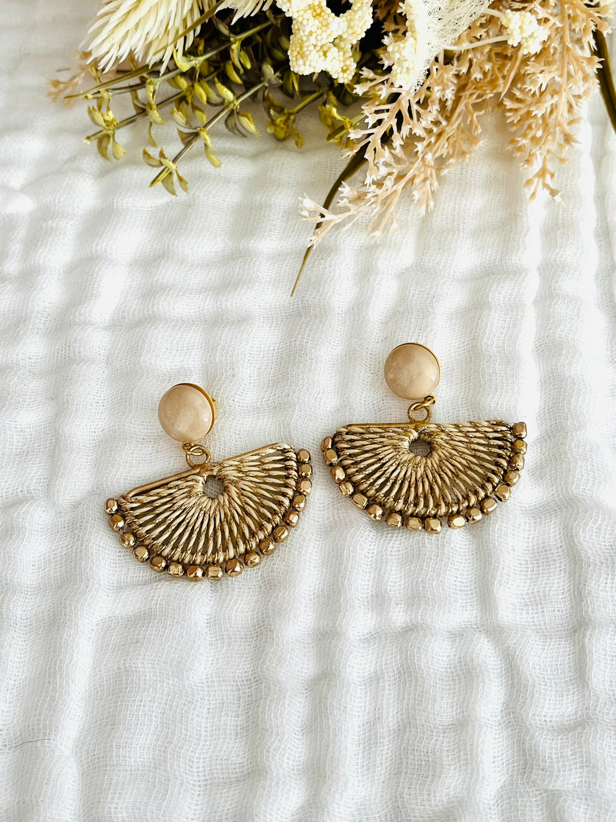 Boucles d'oreilles fantaisie fait main.
Clous d'oreilles en laiton doré orné d'un cabochon beige nacré.
Pendentif éventail tissé beige et doré.
Bijou fantaisie fait main.