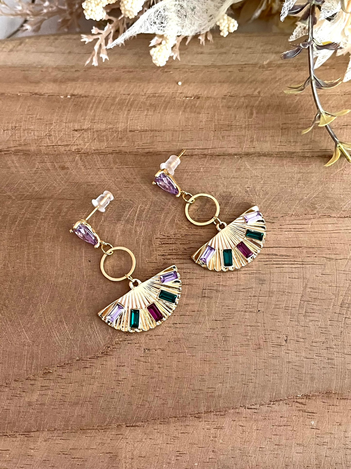 Boucles d'oreilles à clous en forme d'éventail.
Clous d'oreilles en laiton plaqué or 18k et verre parme. Pendentif éventail en laion doré et strass vert, fuchsia, violet.
Bijou fantaisie fait main.
