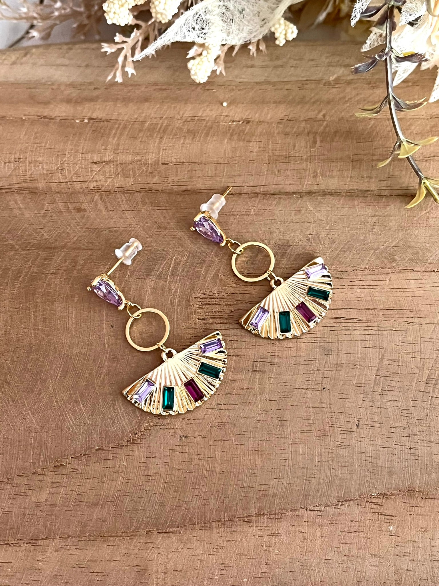 Boucles d'oreilles à clous en forme d'éventail.
Clous d'oreilles en laiton plaqué or 18k et verre parme. Pendentif éventail en laion doré et strass vert, fuchsia, violet.
Bijou fantaisie fait main.