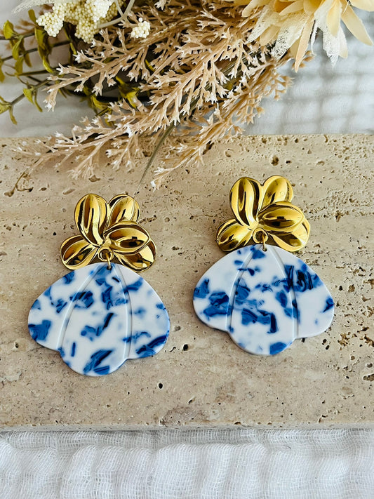 Boucles d'oreilles fantaisie fait main.
Clous d'oreilles fleur en acier inoxydable doré. Pendentifs pétale, éventail en acrylique bleu et blanc.
Bijou fait main.