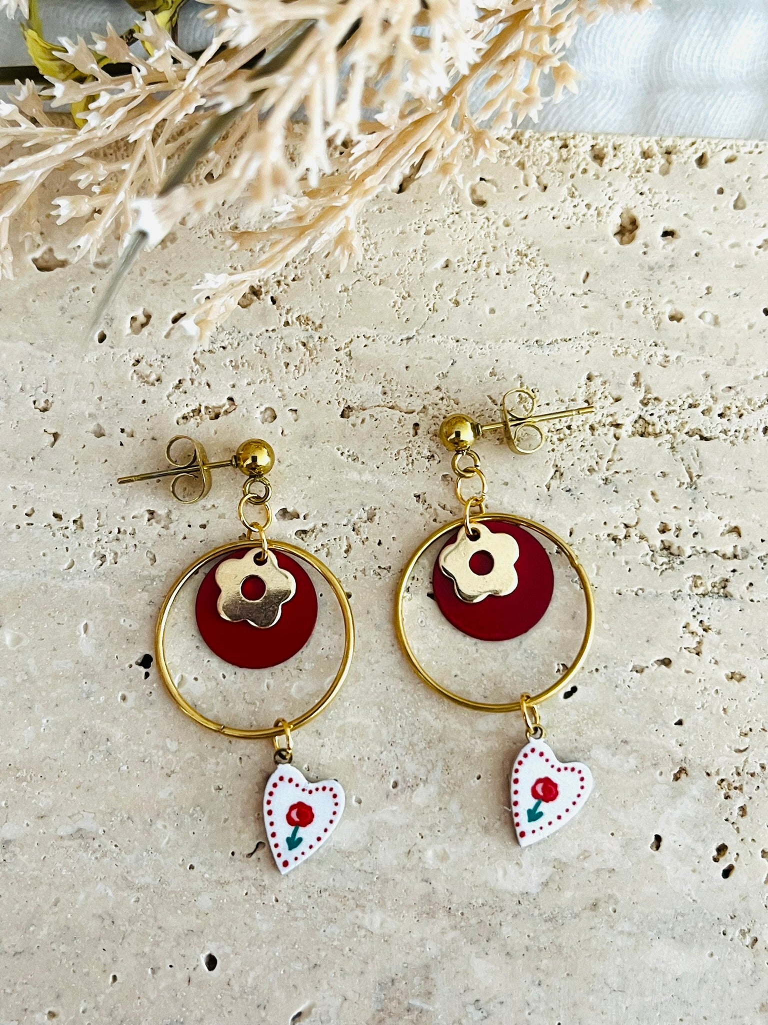 Boucles d'oreilles fantaisie fait main en acier inoxydable doré.
Clous d'oreilles boule, anneaux fermés de 20mm, breloque coeur imprimé pivoine rouge, pastille ronde rouge, pampille fleur.

Bijou fantaisie fait main.