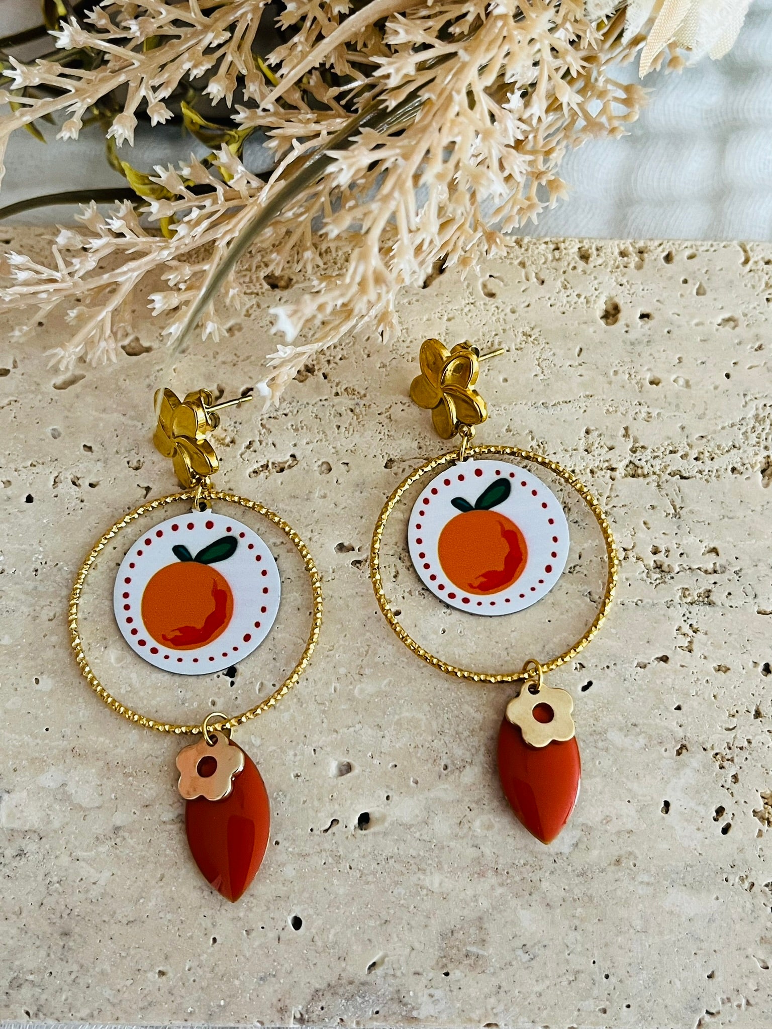 Boucles d'oreilles fantaisie fait main en acier inoxydable doré.
Clous d'oreilles fleur, anneaux ciselés de 30mm, pendentifs ronds imprimé fruit orange sur fond blanc, sequin navette émaillé orange, pampilles fleurs.

Bijou fantaisie fait main.