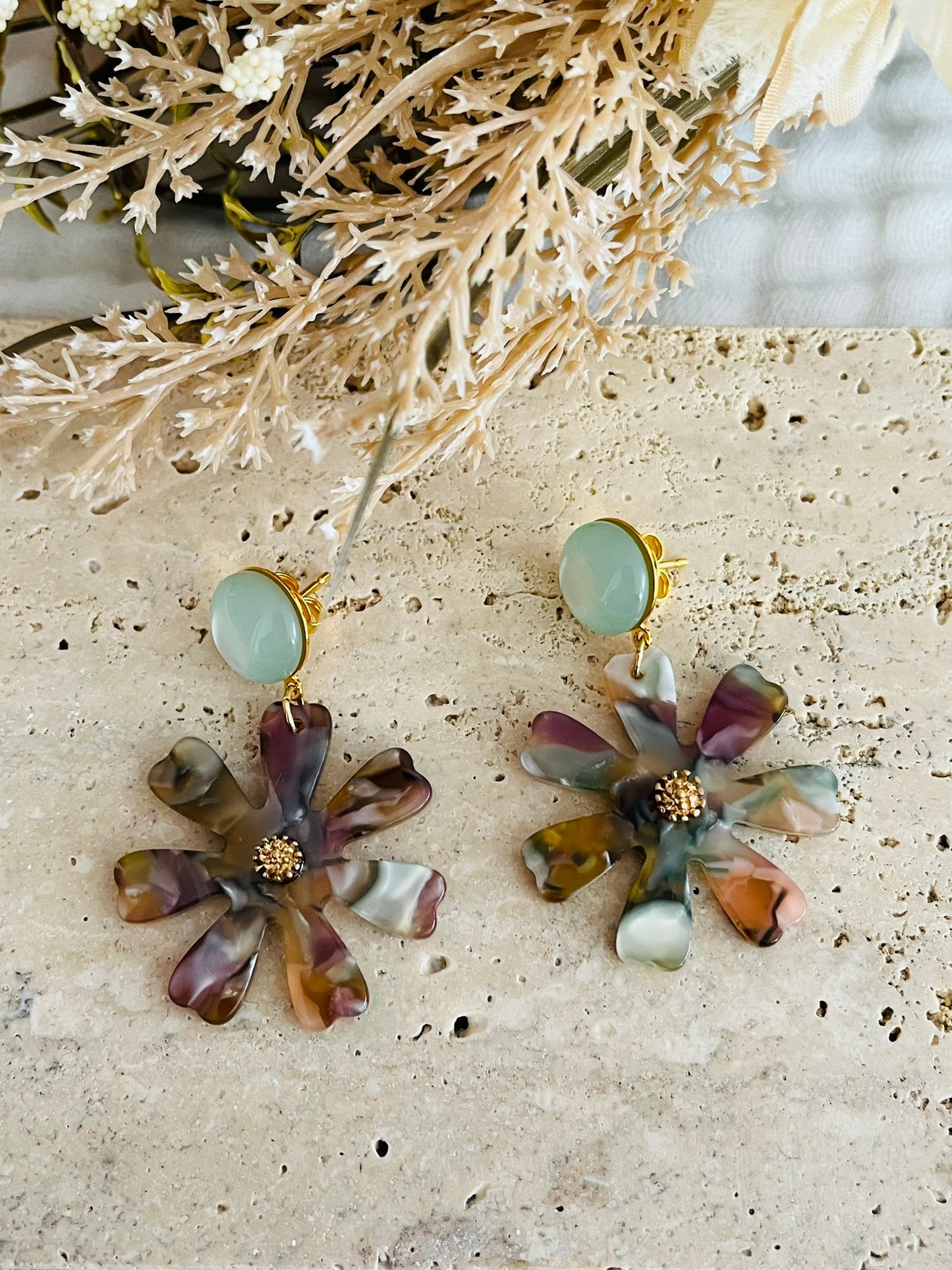 Boucles d'oreilles fantaisie fait main.
Clous d'oreilles rond avec cabochon en résine décliné en 4 couleurs: terracotta mat, vert d'eau, rose, bronze.
Pendentif marguerite en acrylique marbré multicolore.
Bijou fantaisie fait main.