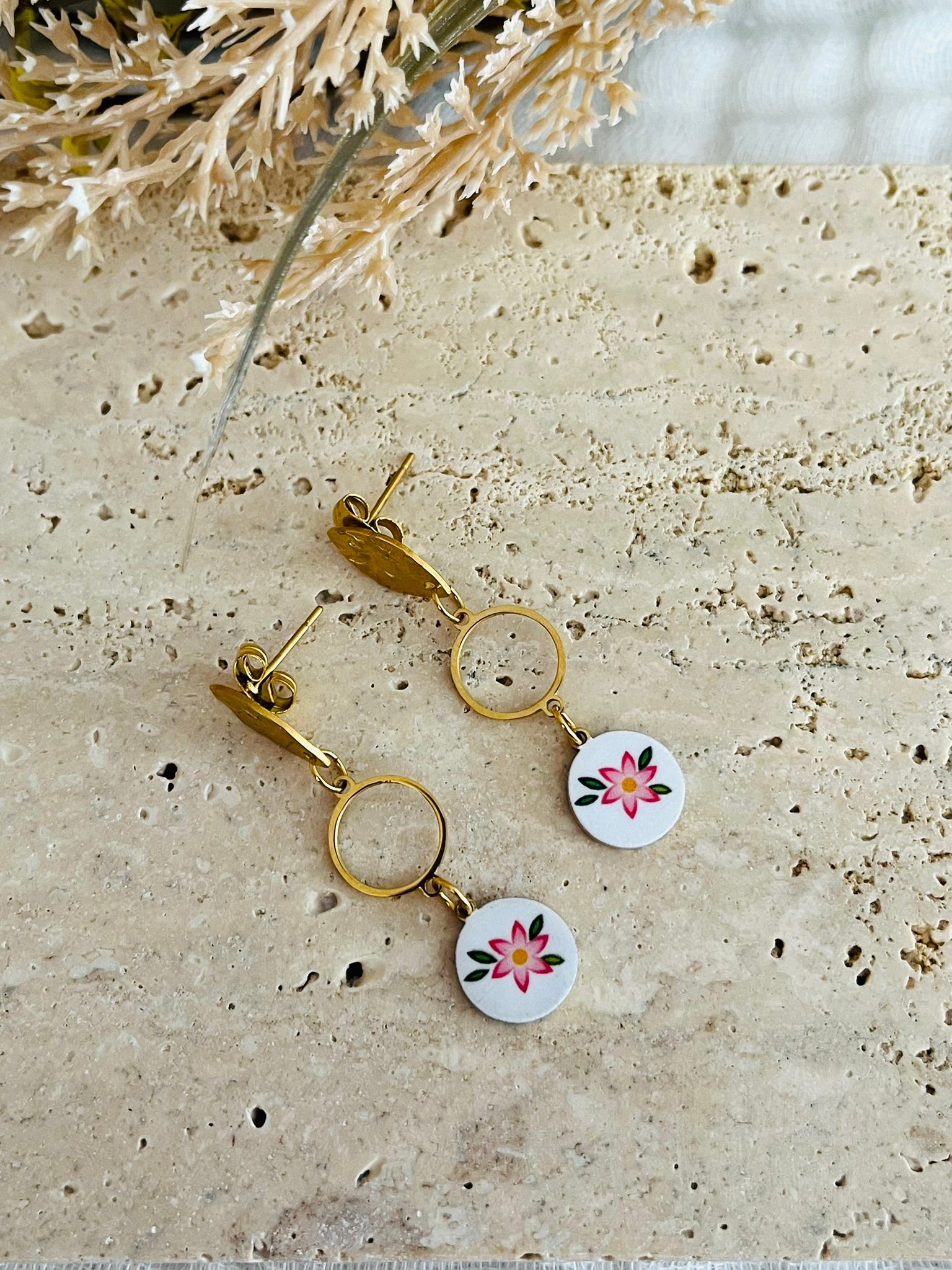 Boucles d'oreilles fantaisie en acier inoxydable doré.
Clous d'oreilles ovales martelés, intercalaires ronds de 10mm,breloques rondes imprimé fleur rose sur fond blanc.

Bijou fantaisie fait main.