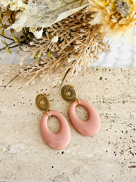 Boucles d'oreilles fantaisie fait main.
Esprit vintage avec ses pendentifs ovales en acrylique rose. CLous d'oreilles ronds soleil en acier inoxydable doré.
Bijou fantaisie fait main.