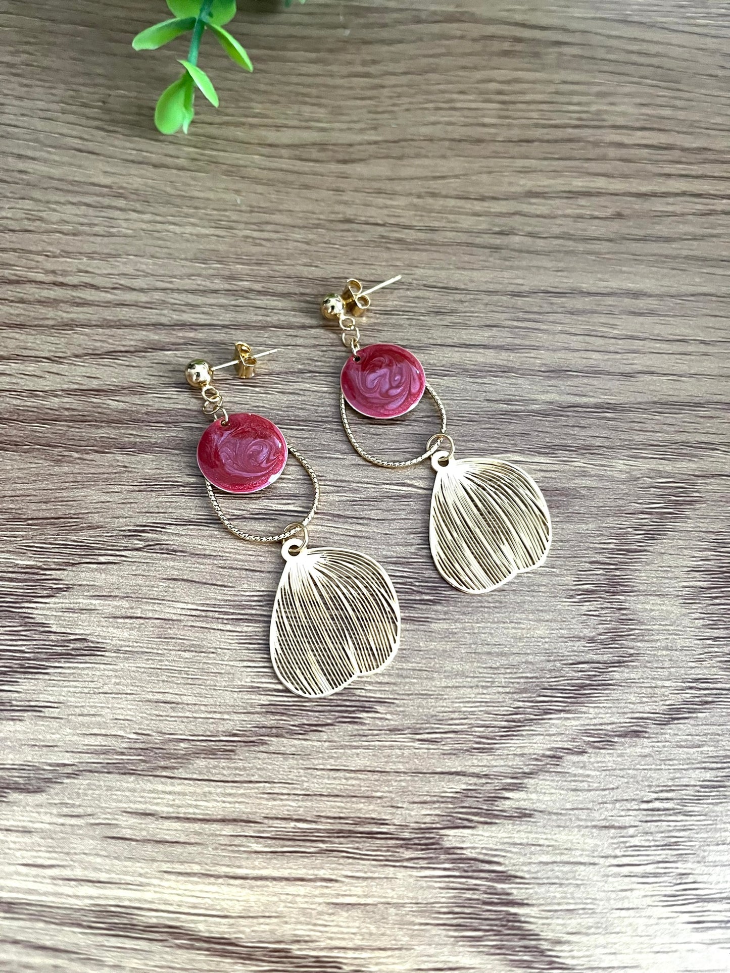 Boucles d'oreilles fantaisie fait main.
Clous d'oreilles doré, gouttes ciselées et estampes feuille en laiton doré à l'or fin 18k. Sequins ronds bordeaux nacré.
Bijou fantaisie fait main.