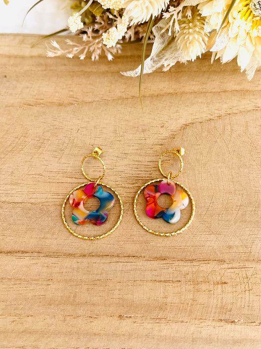 Boucles d'oreilles fantaisie fait main.
Clous d'oreilles ronds en acier inox doré, anneau fermé ciselé en acier doré, fleur multicolore en acrylique.
Bijou fantaisie fait main.