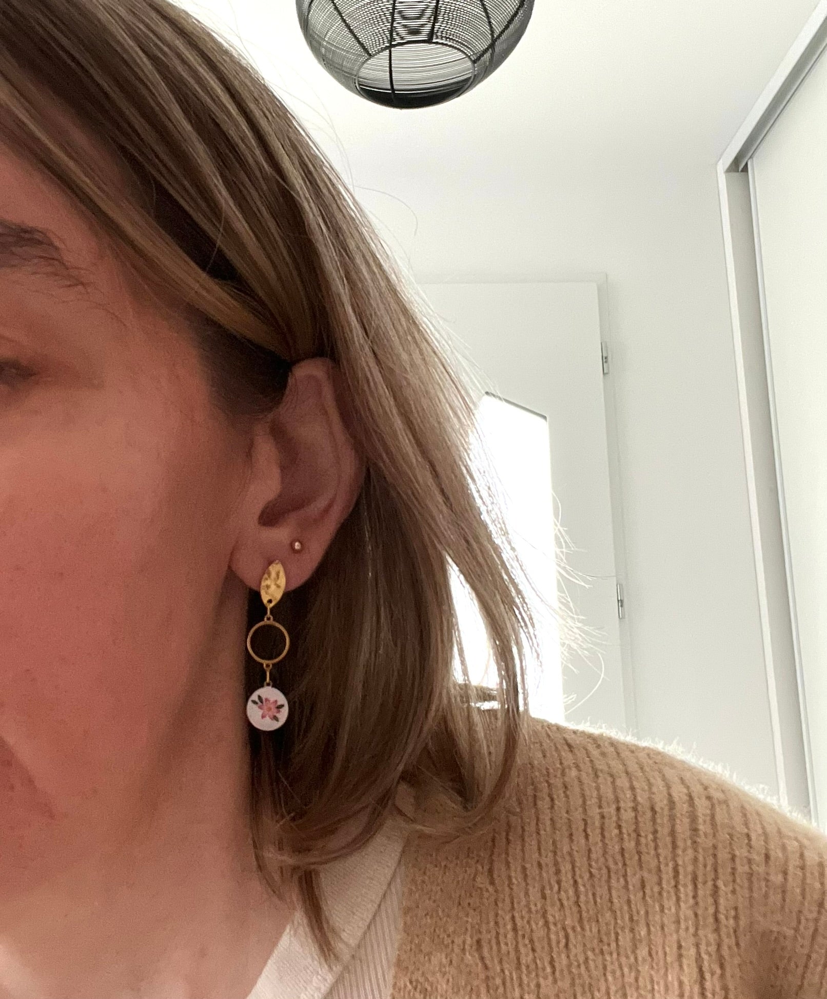 Boucles d'oreilles fantaisie en acier inoxydable doré.
Clous d'oreilles ovales martelés, intercalaires ronds de 10mm,breloques rondes imprimé fleur rose sur fond blanc.

Bijou fantaisie fait main.
