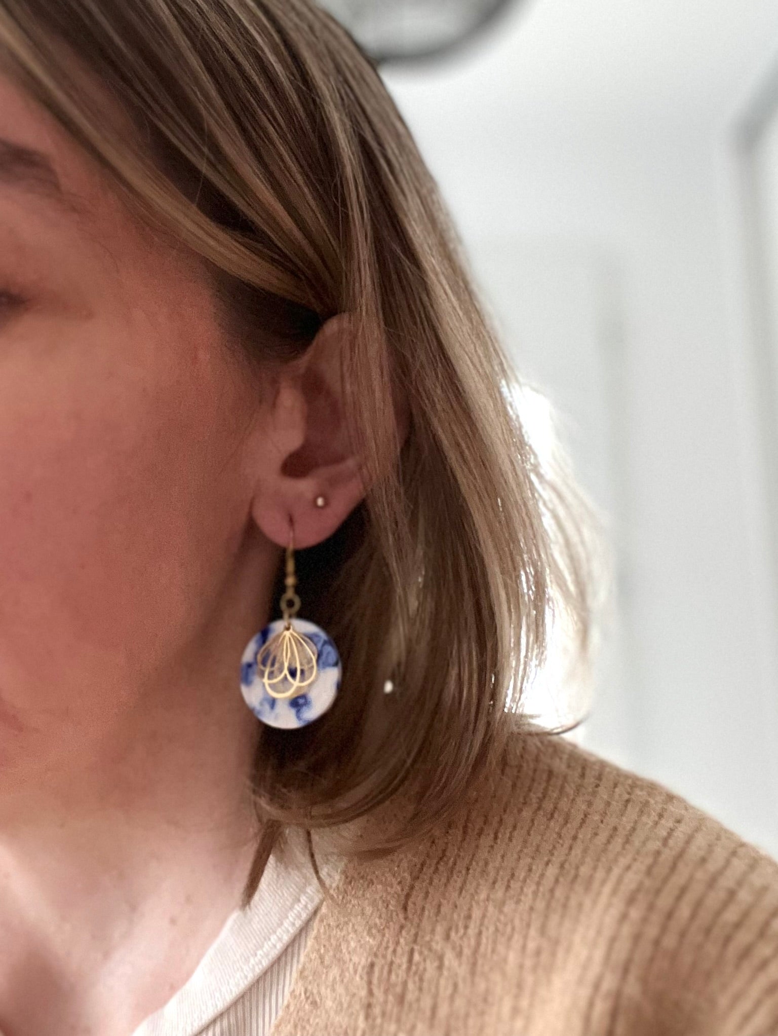 Boucles d'oreilles fantaisie fait main.
Crochets en acier inox doré. Pendentifs ronds en acrylique blanc marbré bleu. Estampe pétale de fleur en acier inox doré.
Bijou fantaisie fait main.