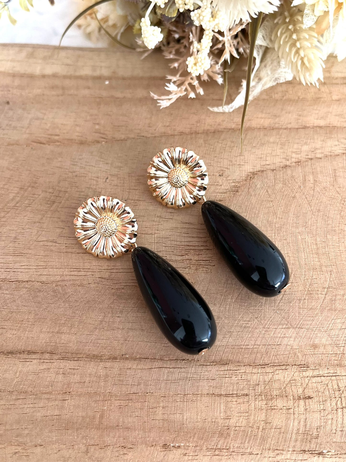 Boucles d'oreilles fantaisie fait main.
Clous d'oreilles fleur en laiton doré.
Perles goutte en résine noir.
Bijou artisanal fait main.