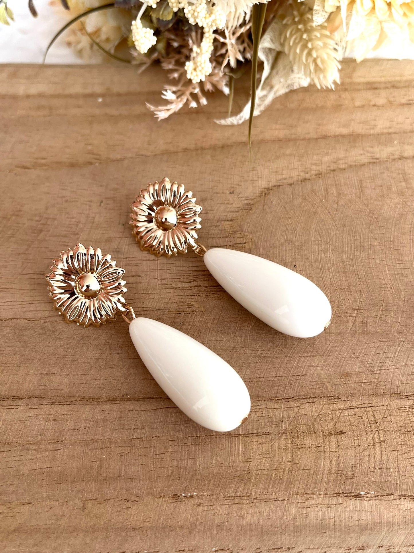 Boucles d'oreilles fantaisie fait main.
Clous d'oreilles fleur en laiton doré.
Perles goutte en résine écru.
Bijou artisanal fait main.