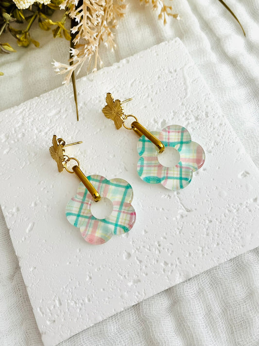 Boucles d'oreilles fantaisie faites main.
Clous d'oreilles fleur en acier inox doré, anneaux ovales en acier doré, pendentif fleur en acrylique motif tartan vert et rose sur fond blanc.
Bijou fait main.