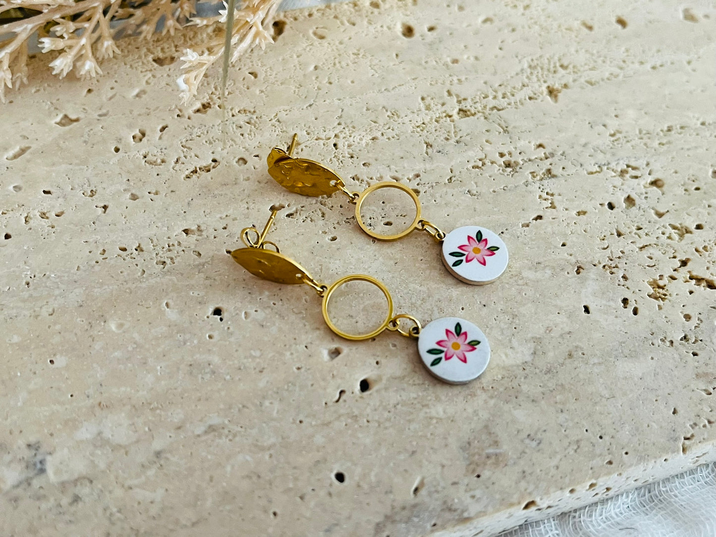 Boucles d'oreilles fantaisie en acier inoxydable doré.
Clous d'oreilles ovales martelés, intercalaires ronds de 10mm,breloques rondes imprimé fleur rose sur fond blanc.

Bijou fantaisie fait main.