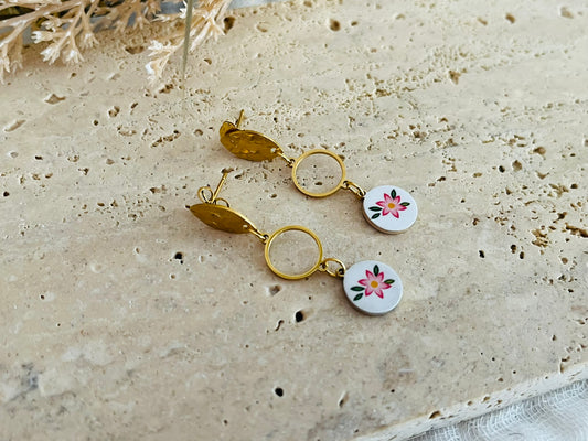 Boucles d'oreilles fantaisie en acier inoxydable doré.
Clous d'oreilles ovales martelés, intercalaires ronds de 10mm,breloques rondes imprimé fleur rose sur fond blanc.

Bijou fantaisie fait main.