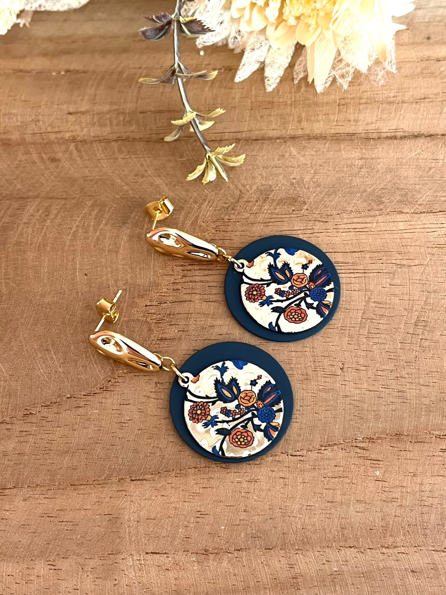 Boucles d'oreilles fantaisie fait main.
Boucles d'oreilles à clous en laiton doré à l'or fin.
Sequins ronds bleu marine, pendentifs motif fleurs doré, bleu et orange.
Bijou fantaisie fait main