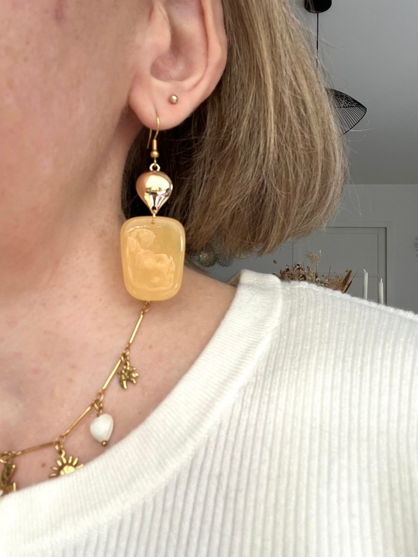 Boucles d'oreilles fantaisie fait main.
Crochets en acier inox doré.
Connecteurs goutte dorés.
Pendentifs trapèze en résine couleur abricot.
Bijou fantaisie fait main.