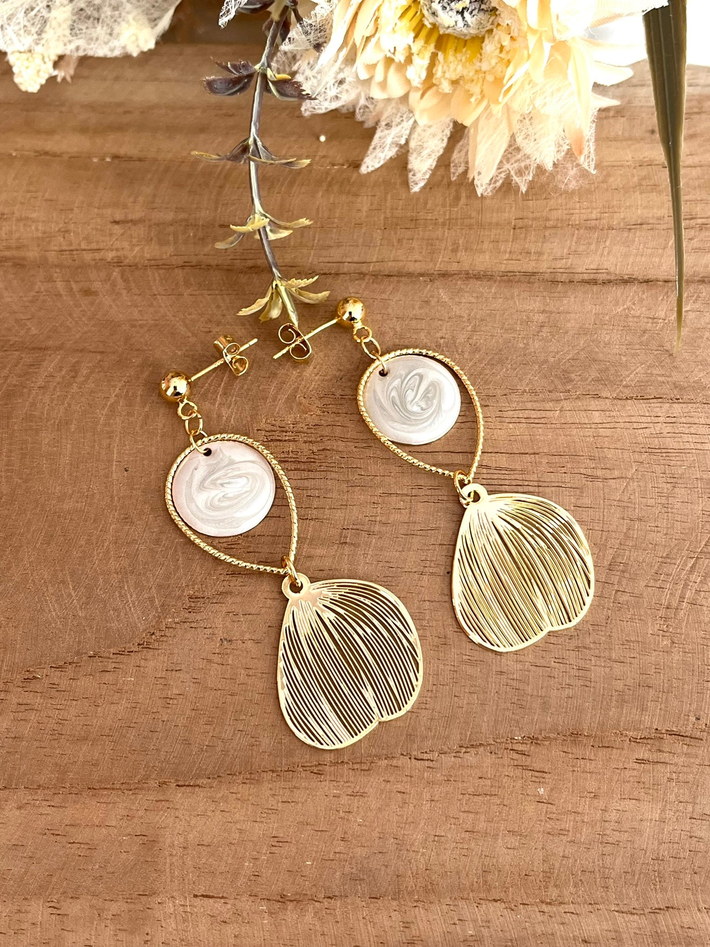 Boucles d'oreilles fantaisie fait main.
Clous d'oreilles doré, gouttes ciselées et estampes feuille en laiton doré à l'or fin 18k. Sequins ronds blanc nacré.
Bijou fantaisie fait main.