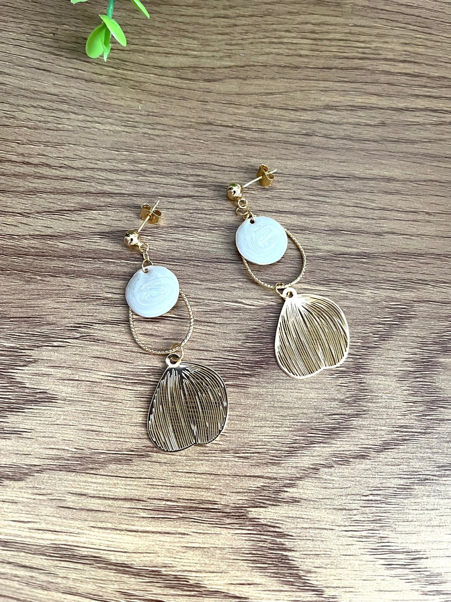 Boucles d'oreilles fantaisie fait main.
Clous d'oreilles doré, gouttes ciselées et estampes feuille en laiton doré à l'or fin 18k. Sequins ronds blanc nacré.
Bijou fantaisie fait main.