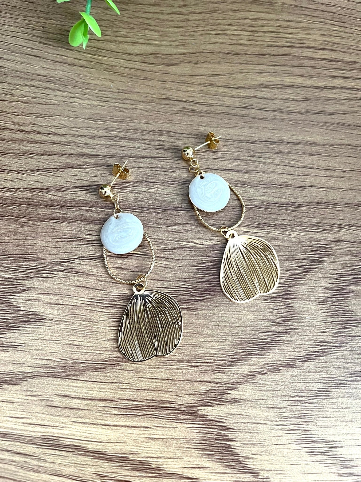 Boucles d'oreilles fantaisie fait main.
Clous d'oreilles doré, gouttes ciselées et estampes feuille en laiton doré à l'or fin 18k. Sequins ronds blanc nacré.
Bijou fantaisie fait main.