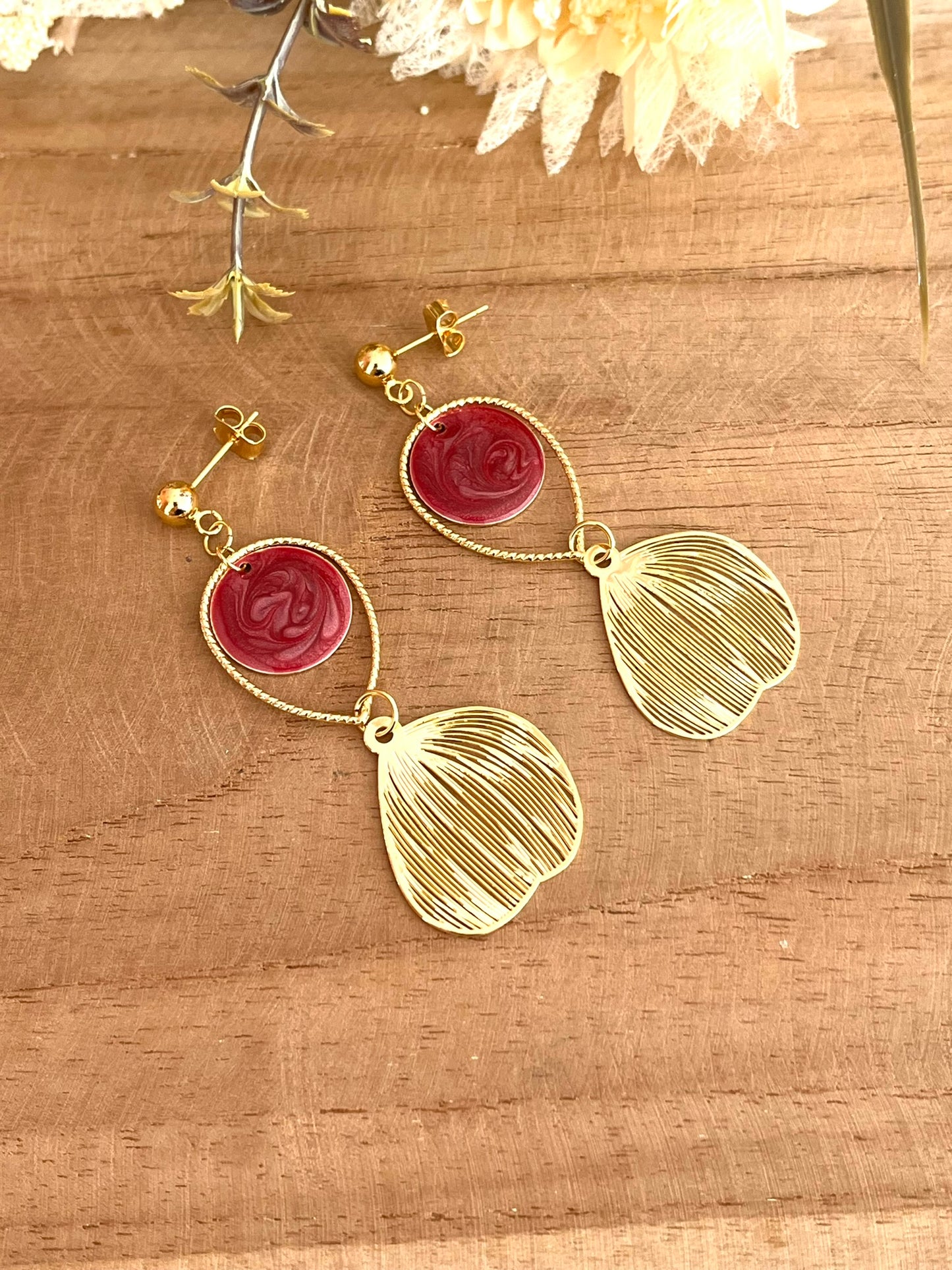 Boucles d'oreilles fantaisie fait main.
Clous d'oreilles doré, gouttes ciselées et estampes feuille en laiton doré à l'or fin 18k. Sequins ronds bordeaux nacré.
Bijou fantaisie fait main.