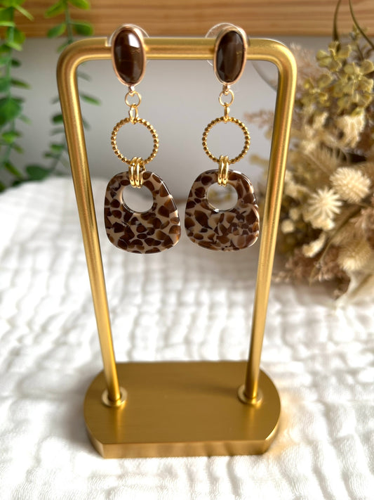 Boucles d'oreilles fantaisie fait main.
Clous d'oreilles marron chocolat et doré; anneaux en acier inoxydable doré; pendentifs trapèze en acrylique motif léopard beige et marron.
Bijou fantaisie fait main