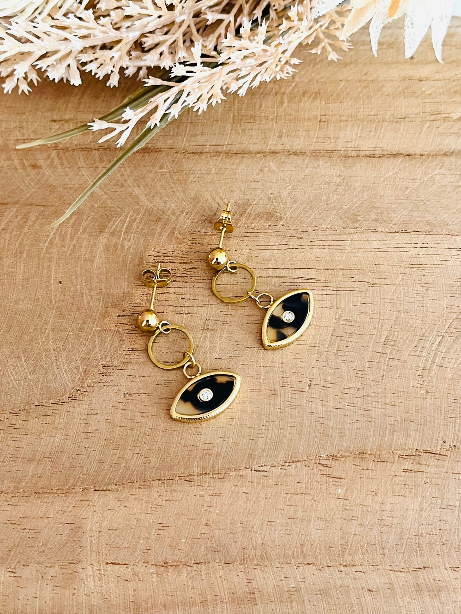 Boucles d'oreilles fantaisie fait main.
Clous d'oreilles en acier inoxydable doré, pendentif oeil beige.
Bijou fantaisie fait main.