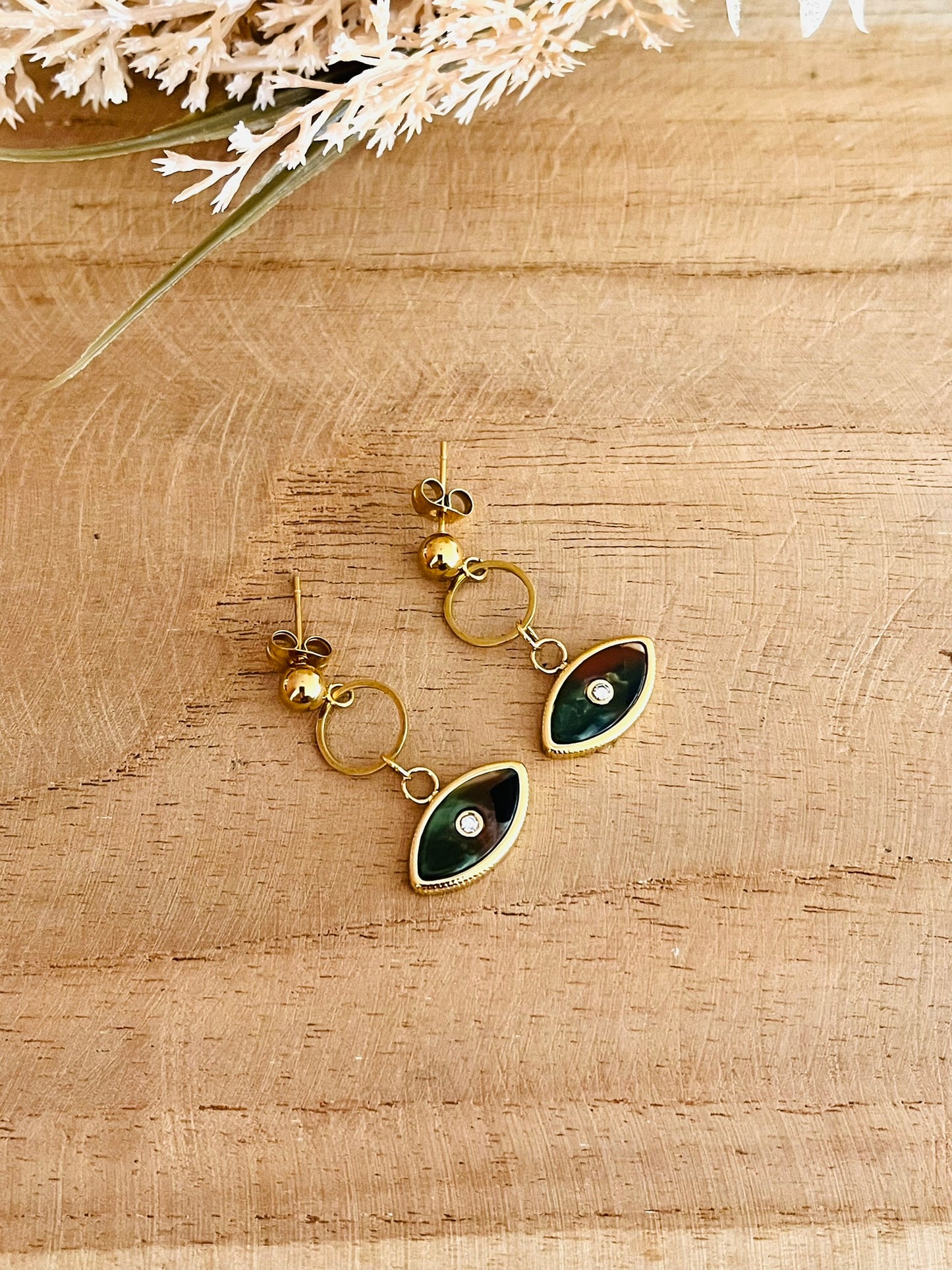 Boucles d'oreilles fantaisie fait main.
Clous d'oreilles en acier inoxydable doré, pendentif oeil vert kaki.
Bijou fantaisie fait main.