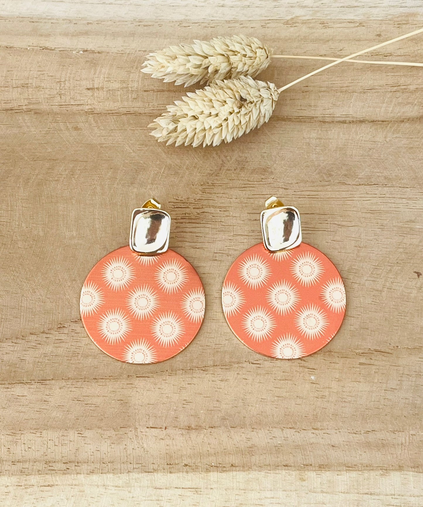 Boucles d'oreilles faites main.
Clous d'oreilles rectangle en laiton doré à l'or fin 18K.
Pendentifs ronds 35mm en métal doré et orange terracotta imprimé de soleils.
Bijou fantaisie fait main.