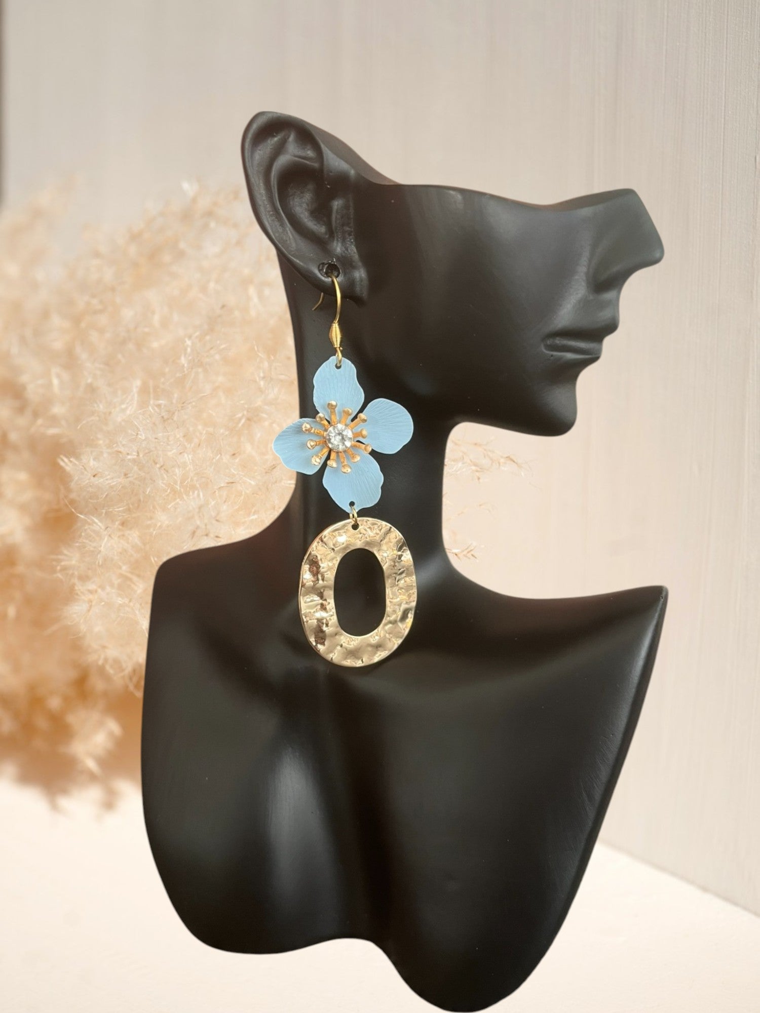 Boucles d'oreilles fantaisie pendantes. Fleur bleu ciel et pendentif ovale martelé doré.
Bijou fantaisie fait main.