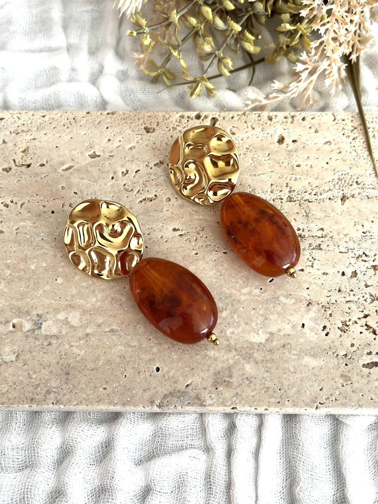 Boucles d'oreilles fantaisie fait main.
Clous d'oreilles ronds martelés en acier inoxydable doré.
Perle ovale en résine ambre marbré.
Bijou fantaisie fait main.