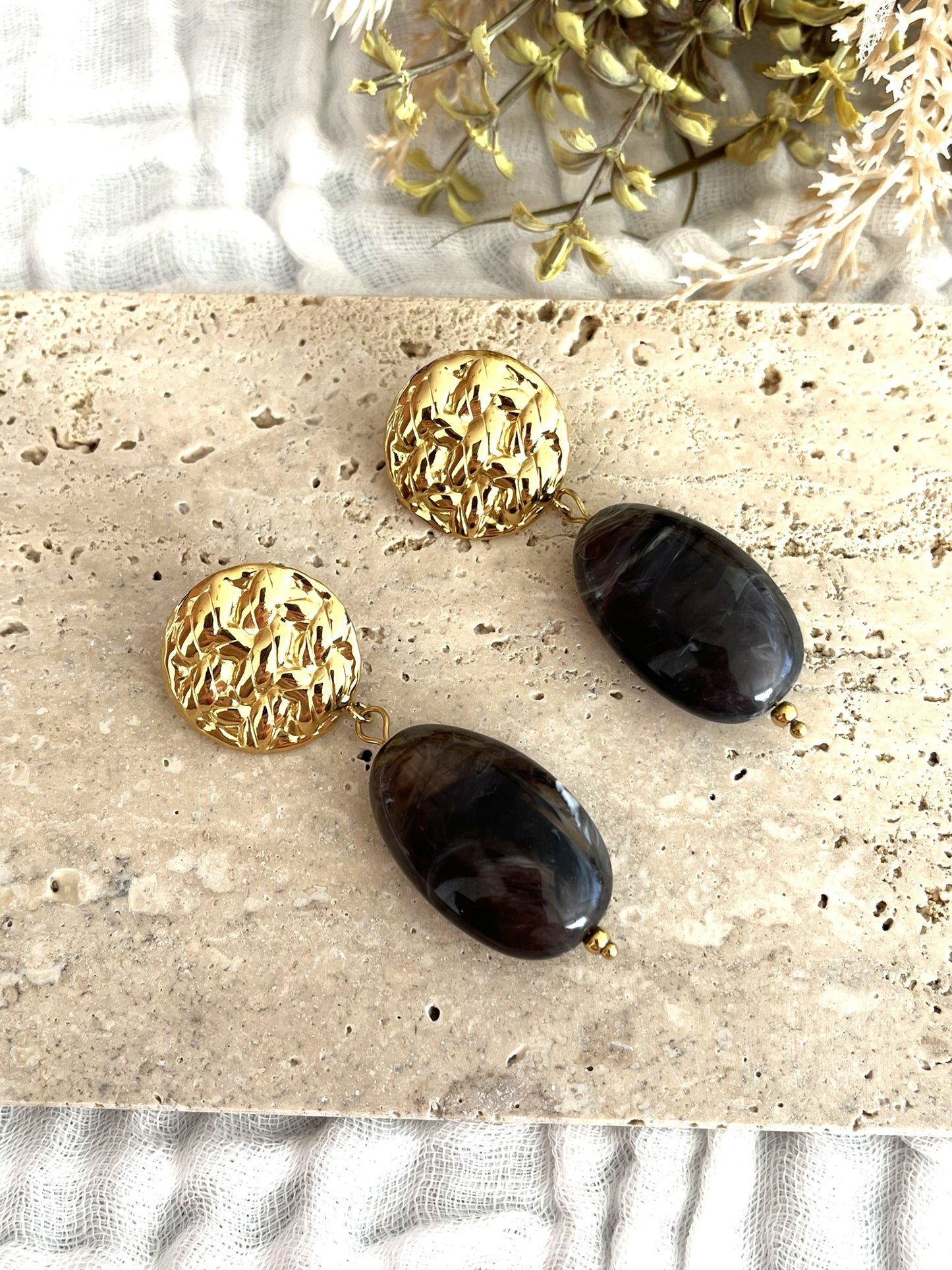 Boucles d'oreilles fantaisie fait main.
Clous d'oreilles ronds martelés en acier inoxydable doré.
Perle ovale en résine rouge marbré.
Bijou fantaisie fait main.