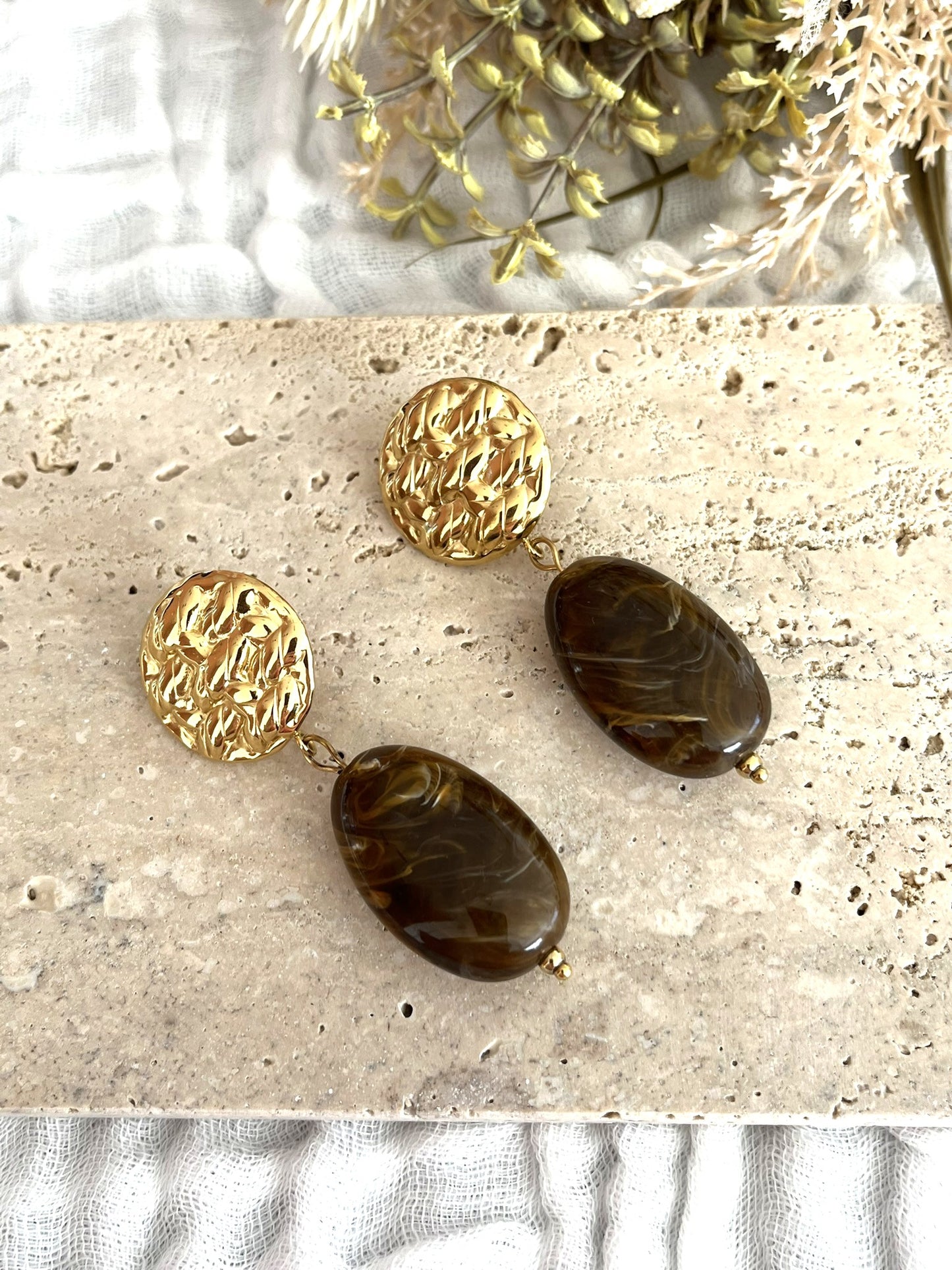 Boucles d'oreilles fantaisie fait main.
Clous d'oreilles ronds martelés en acier inoxydable doré.
Perle ovale en résine rouge marbré.
Bijou fantaisie fait main.