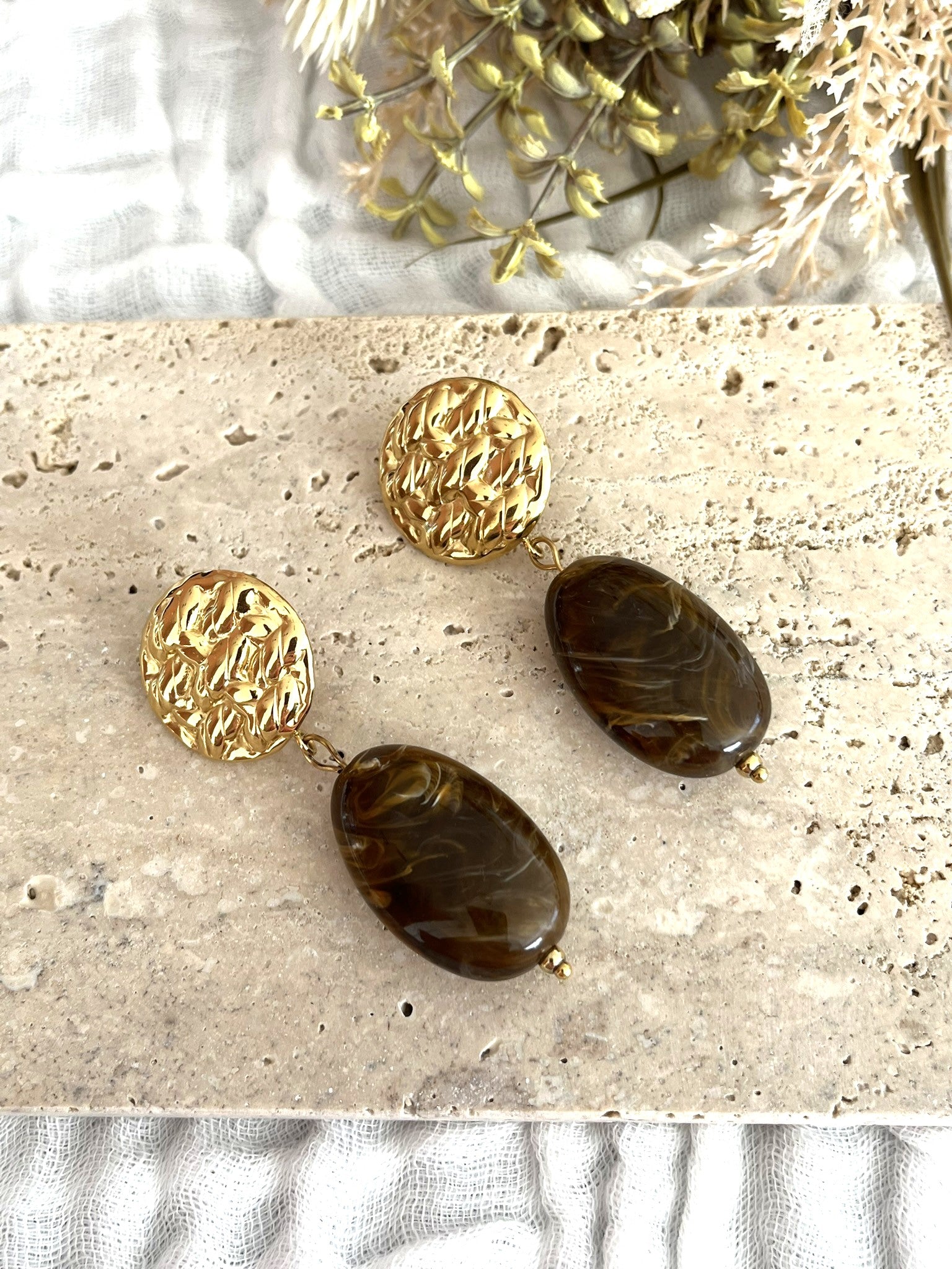 Boucles d'oreilles fantaisie fait main.
Clous d'oreilles ronds martelés en acier inoxydable doré.
Perle ovale en résine rouge marbré.
Bijou fantaisie fait main.