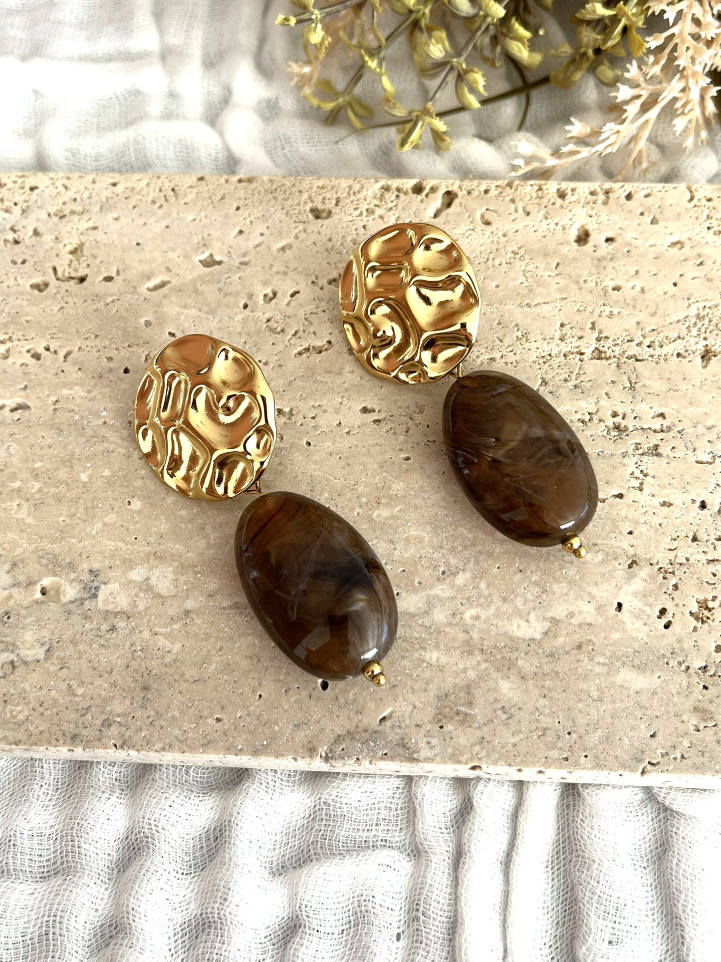 Boucles d'oreilles fantaisie fait main.
Clous d'oreilles ronds martelés en acier inoxydable doré.
Perle ovale en résine marron marbré.
Bijou fantaisie fait main.