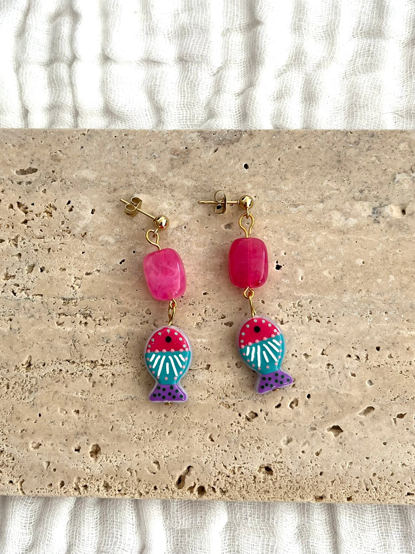 Boucles d'oreilles fantaisie fait main.
Clous d'oreilles boule en acier inox doré;
Perle rectangle en acrylique rose fuchsia;
Perle poisson en verre fuchsia, turquoise, violet.
Bijou fait main.