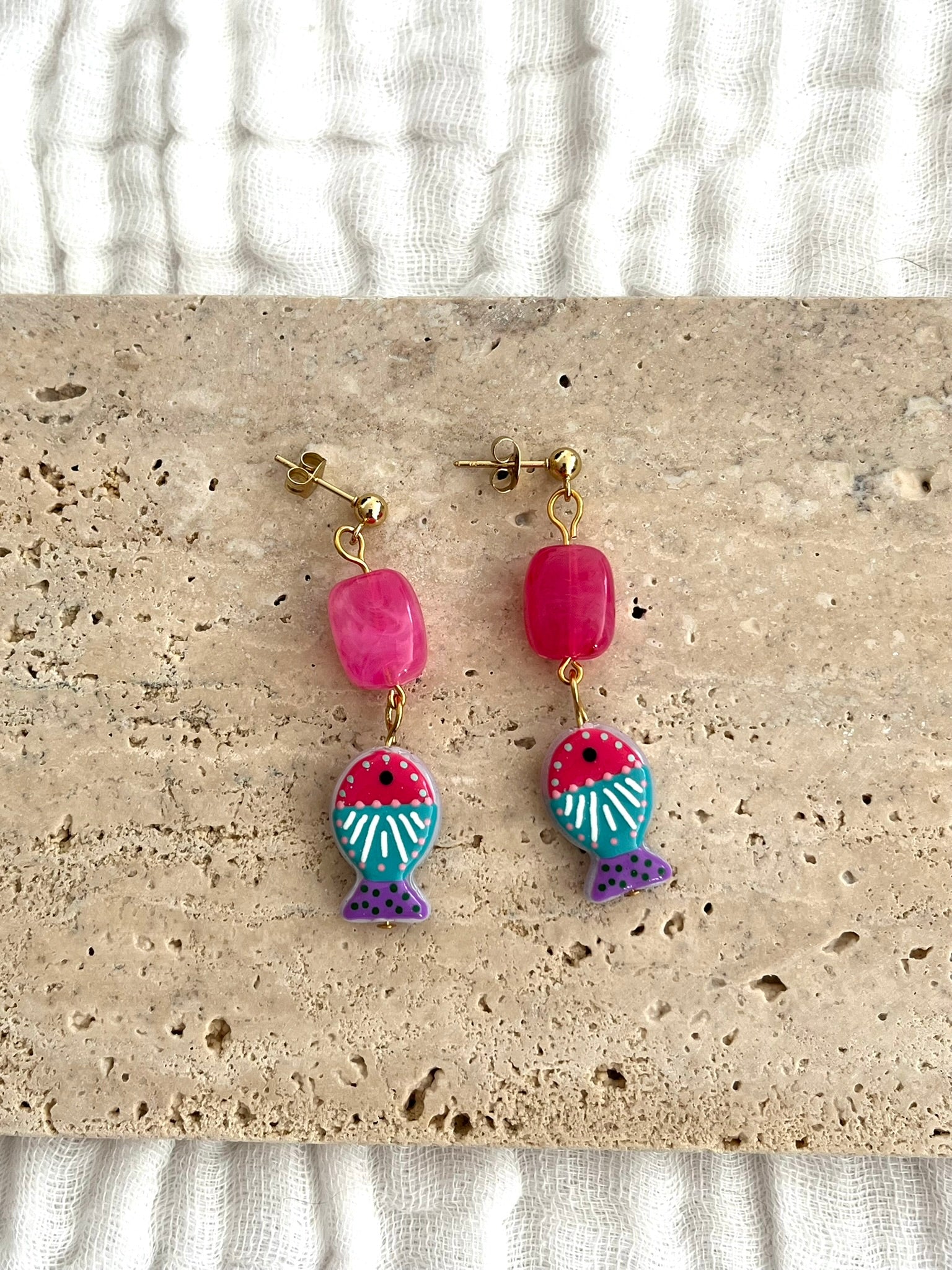 Boucles d'oreilles fantaisie fait main.
Clous d'oreilles boule en acier inox doré;
Perle rectangle en acrylique rose fuchsia;
Perle poisson en verre fuchsia, turquoise, violet.
Bijou fait main.