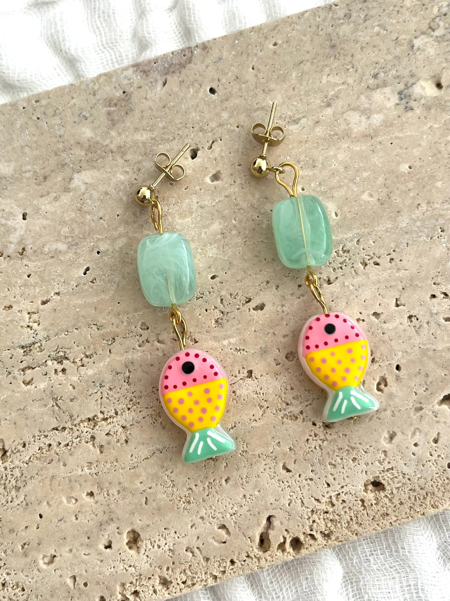 Boucles d'oreilles fantaisie fait main.
Clous d'oreilles boule en acier inox doré;
Perle rectangle en acrylique vert pastel;
Perle poisson en verre vert pastel, rose, jaune.
Bijou fait main.