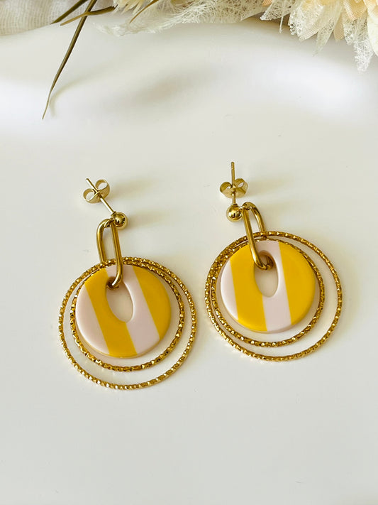Boucles d'oreilles fantaisie fait main.
Clous d'oreilles en acier doré.
Jeu d'anneaux ciselés de 25 et 30mm en acier doré.
Pendentifs ronds en acrylique rayés jaune et blanc.
Bijou fantaisie fait main.