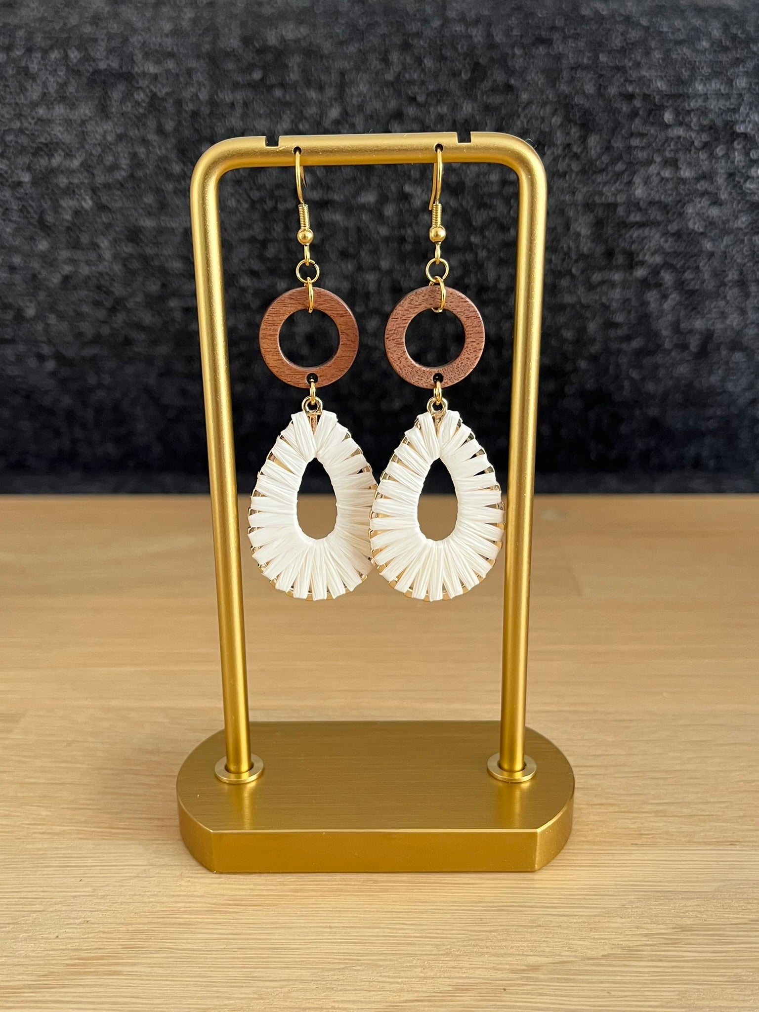Boucles d'oreilles pendantes en raphia écru et bois.
Crochets d'oreilles en acier inoxydable doré.
Bijou fait main.