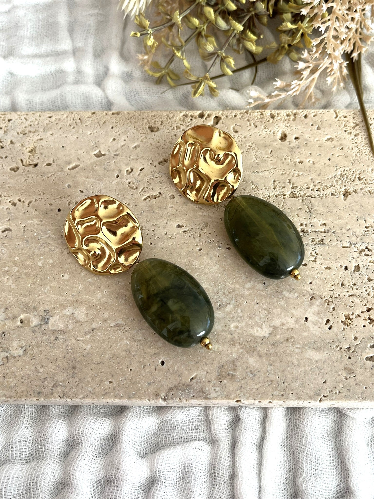 Boucles d'oreilles fantaisie fait main.
Clous d'oreilles ronds martelés en acier inoxydable doré.
Perle ovale en résine vert olive marbré.
Bijou fantaisie fait main