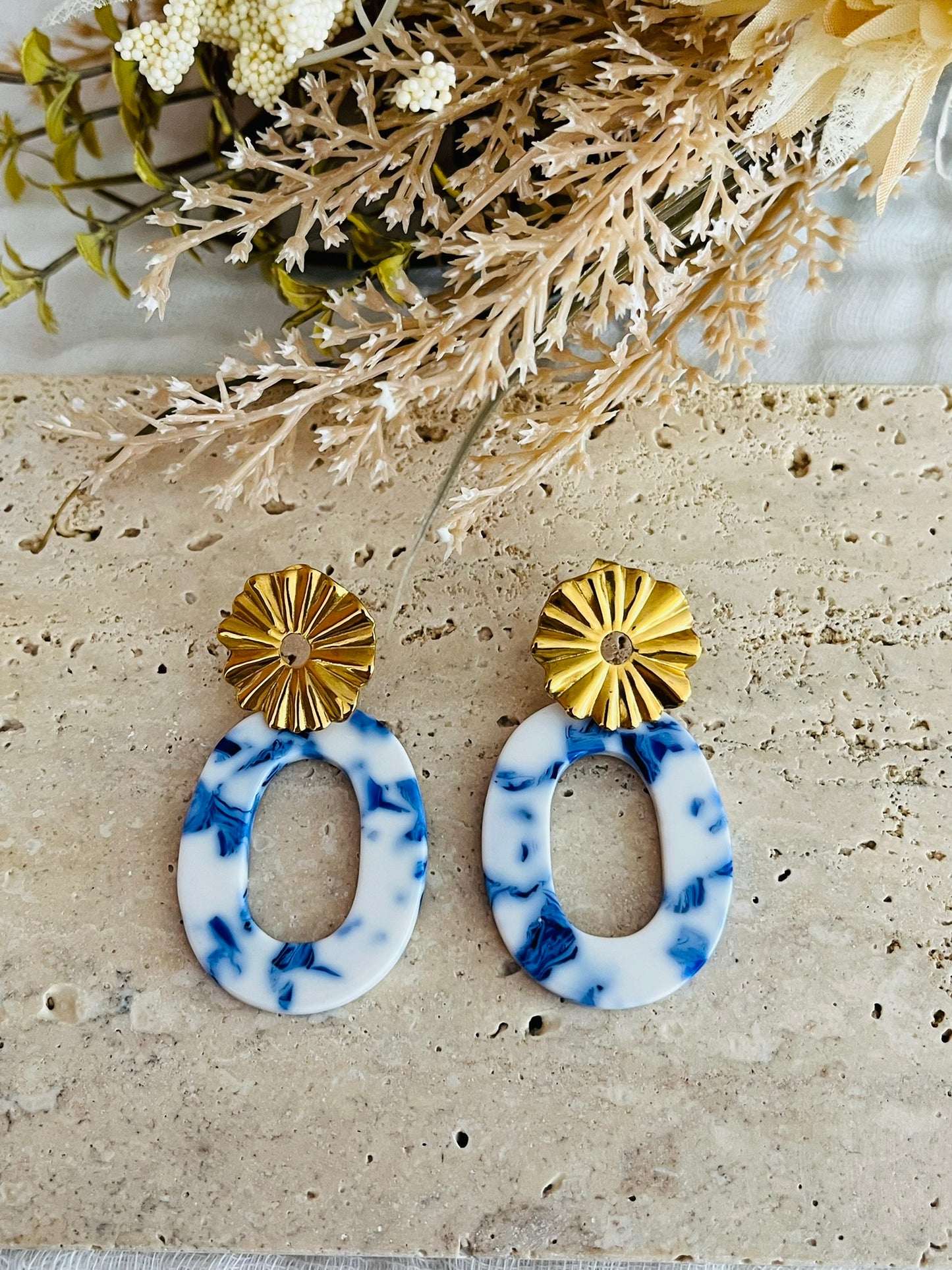 Boucles d'oreilles fantaisie fait main.
Clous d'oreilles soleil plissé en acier inoxydable doré.
Pendentif ovale évidé en acrylique marbré bleu & blanc.
Bijou fait main.