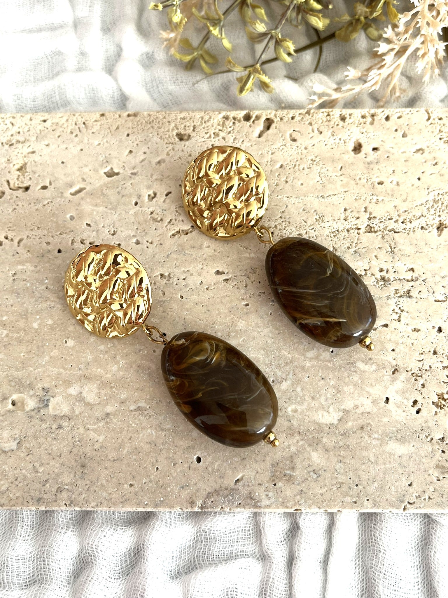 Boucles d'oreilles fantaisie fait main.
Clous d'oreilles ronds martelés en acier inoxydable doré.
Perle ovale en résine rouge marbré.
Bijou fantaisie fait main.