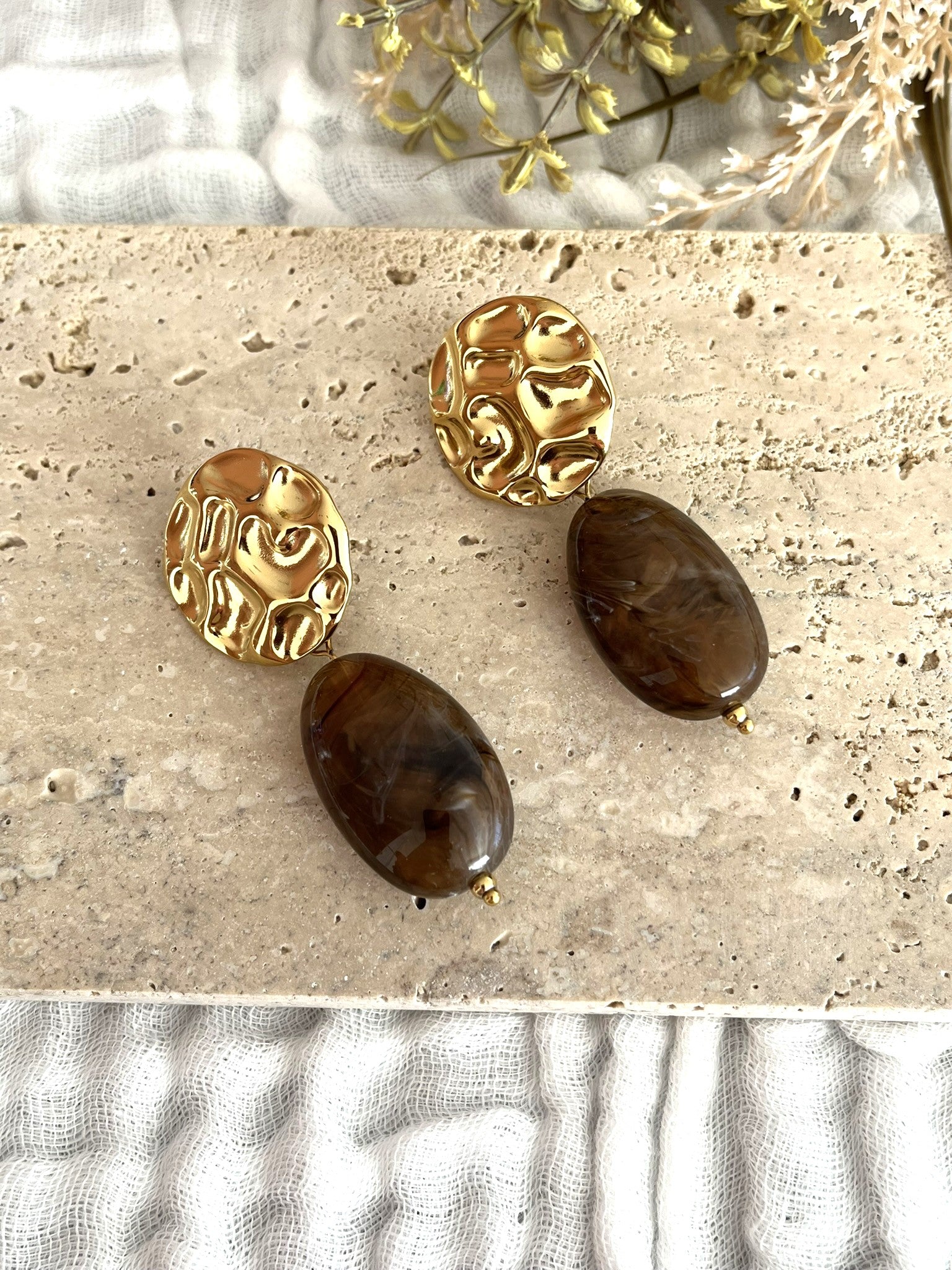 Boucles d'oreilles fantaisie fait main.
Clous d'oreilles ronds martelés en acier inoxydable doré.
Perle ovale en résine marron marbré.
Bijou fantaisie fait main.