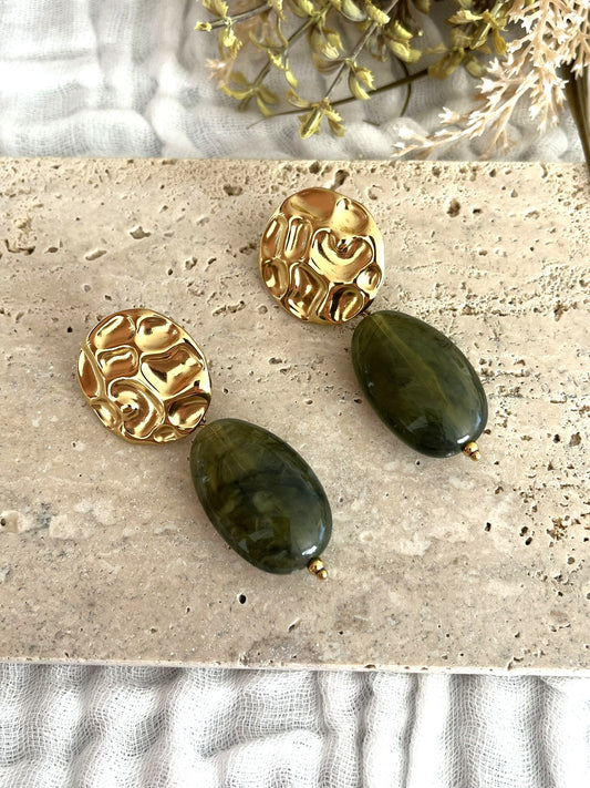 Boucles d'oreilles fantaisie fait main.
Clous d'oreilles ronds martelés en acier inoxydable doré.
Perle ovale en résine vert olive marbré.
Bijou fantaisie fait main.