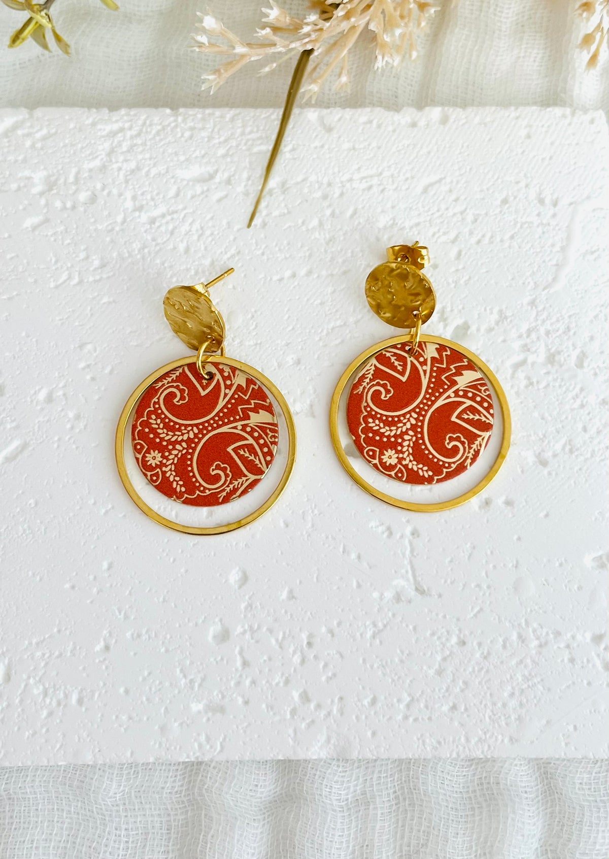 Boucles d'oreilles fantaisie fait main.
Clous d'oreilles ronds martelés doré en acier inox; annaux fermés en acier inox doré, pendentif rond motif bandana, cachemire terracotta et or.
Bijou fantaisie fait main.