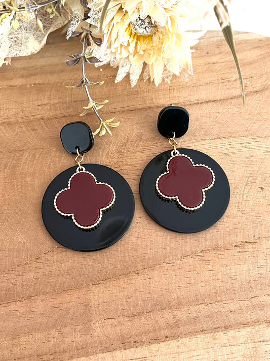 Boucles d'oreilles fantaisie faites main.
clous d'oreilles carrés en acrylique noir, pendentifs ronds en acrylique noir. Trèfle bordeaux et doré.
Bijou fantaisie fait main.