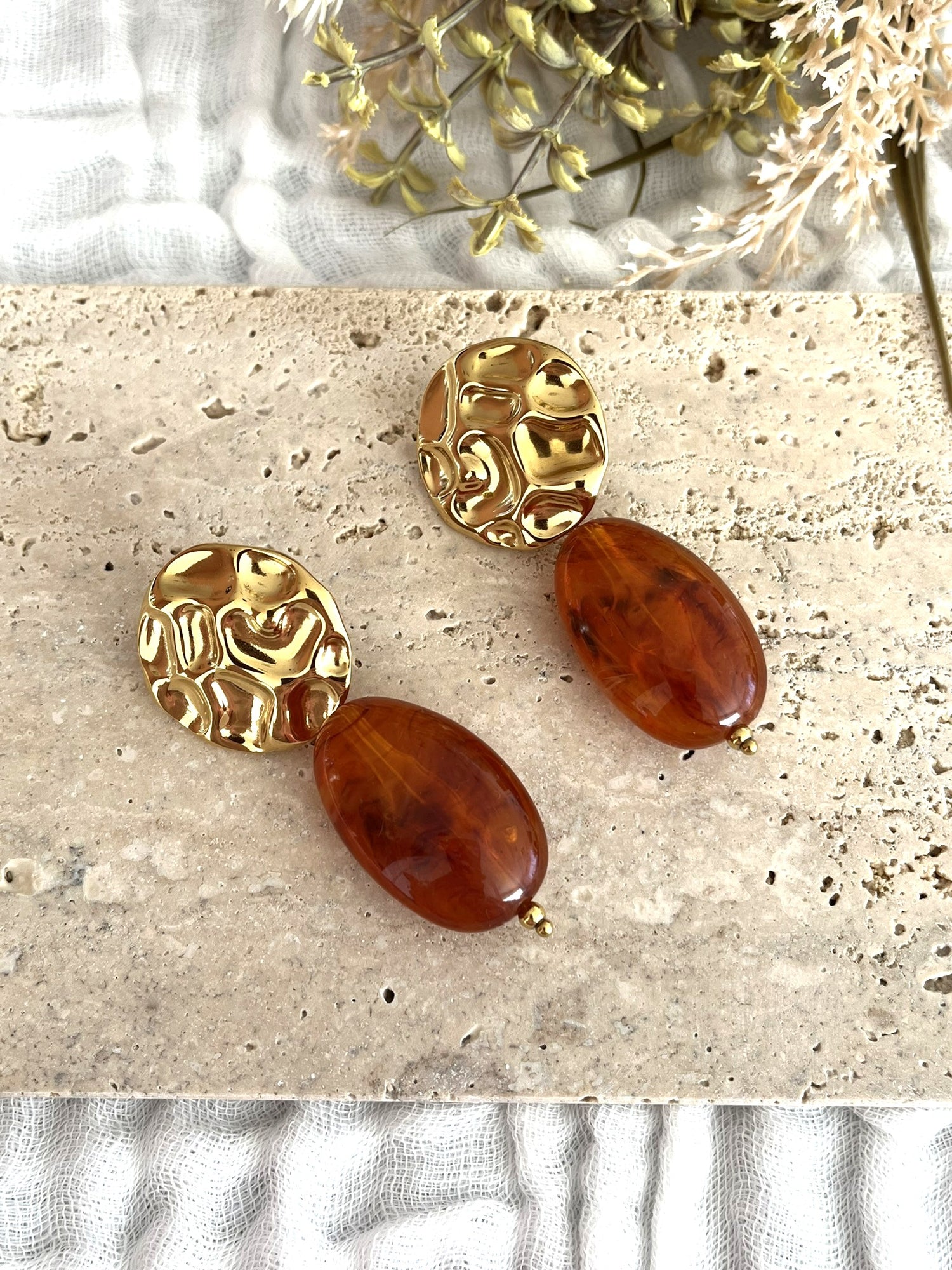 Boucles d'oreilles fantaisie fait main.
Clous d'oreilles ronds martelés en acier inoxydable doré.
Perle ovale en résine ambre marbré.
Bijou fantaisie fait main.