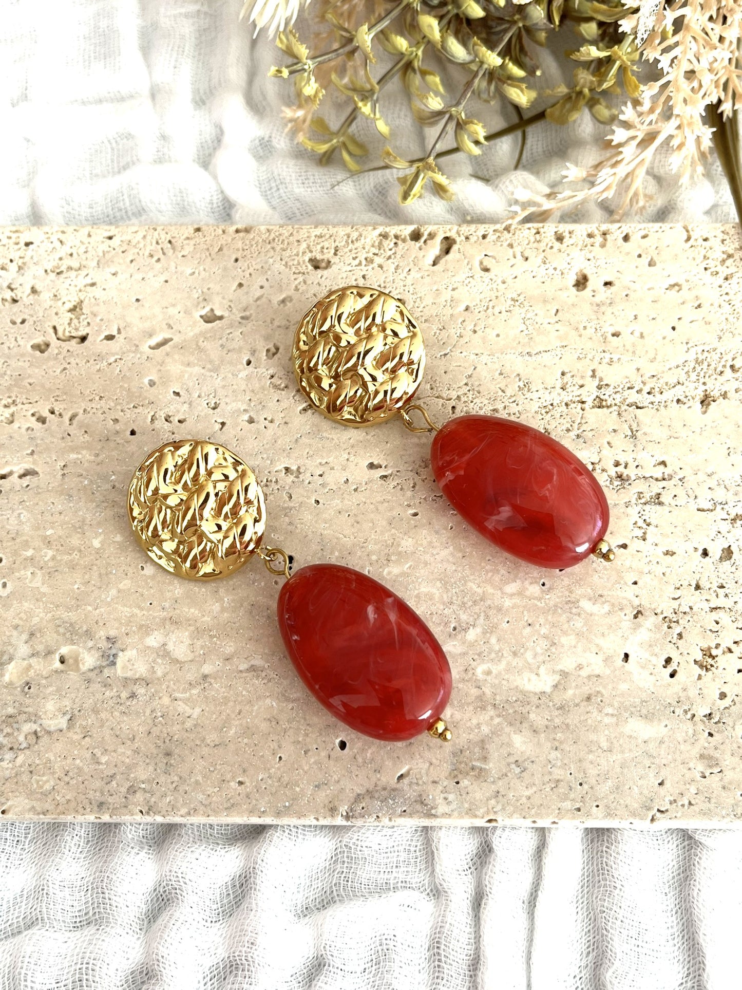 Boucles d'oreilles fantaisie fait main.
Clous d'oreilles ronds martelés en acier inoxydable doré.
Perle ovale en résine rouge marbré.
Bijou fantaisie fait main.