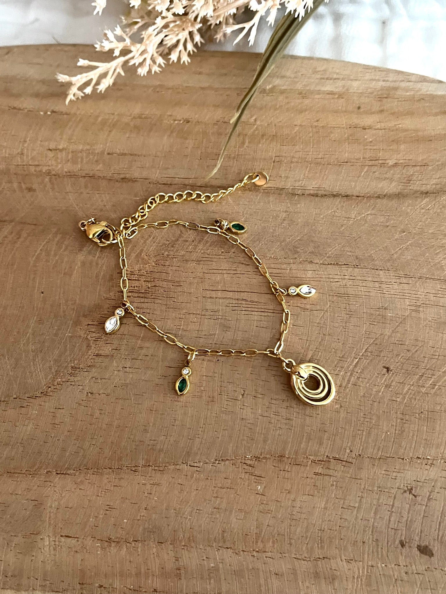 Bracelet fantaisie fait main.
Bracelet à charms en acier inoxydable doré orné de pampilles en zircon vert et cristal, une breloque ovale en acier doré.
Bijou fantaisie fait main.