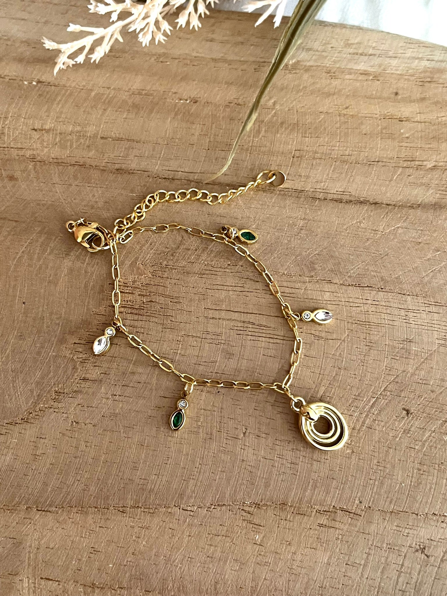 Bracelet fantaisie fait main.
Bracelet à charms en acier inoxydable doré orné de pampilles en zircon vert et cristal, une breloque ovale en acier doré.
Bijou fantaisie fait main.